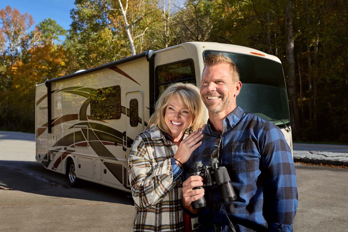 2022 Thor Hurricane Class A RV Lifestyle Tennessee Couple smiling motorhome centered behind Fall Leaves