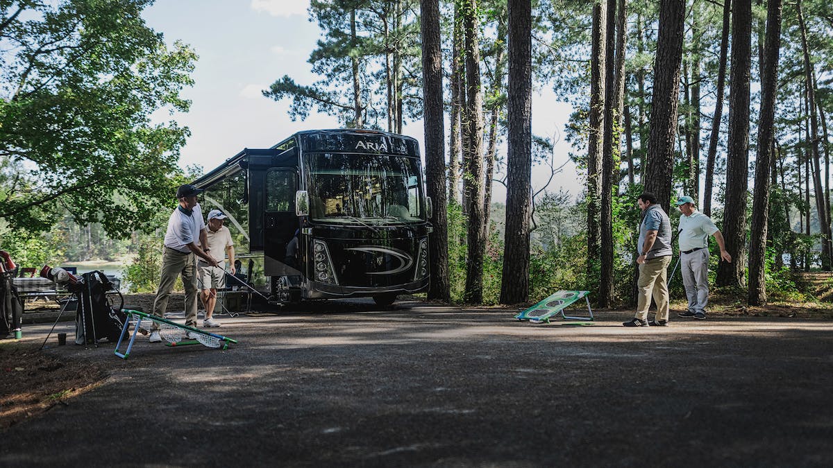 Men golfing in front of an Aria Class A Motorhome