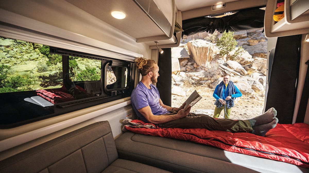 2021 Thor Sanctuary Sprinter Van Sprinter RV lifestyle corporate photo shoot in Utah inside man sitting on bed